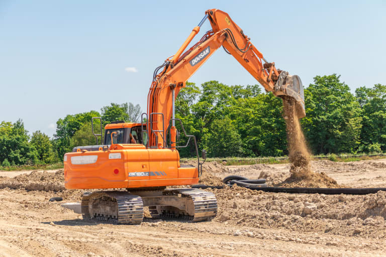 excavator rental digging and dumping dirt on a construction site