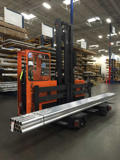 Forklift transporting steel pipes