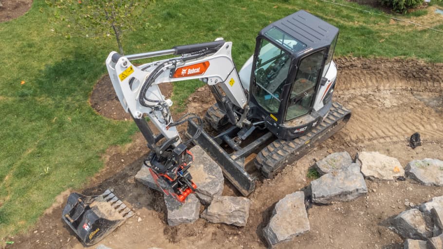 Mini excavator with attachment on it working on construction site